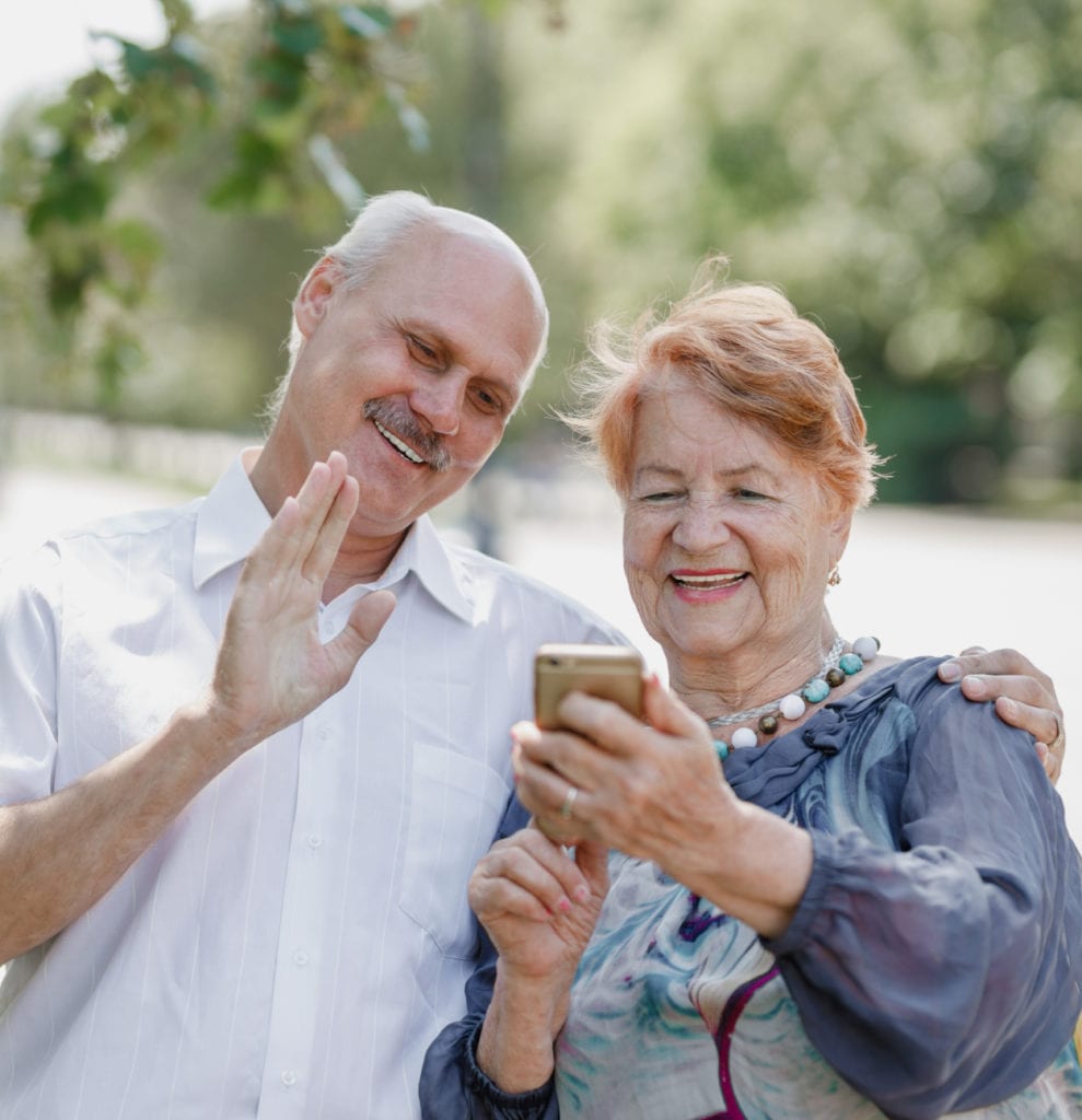 pareja mayor de raza blanca usando el teléfono-Beneficios de Medicare Advantage
