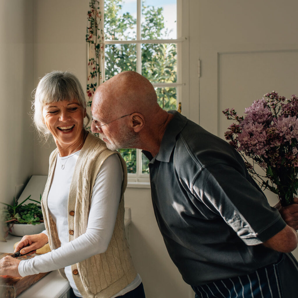 Man surprising woman with flowers